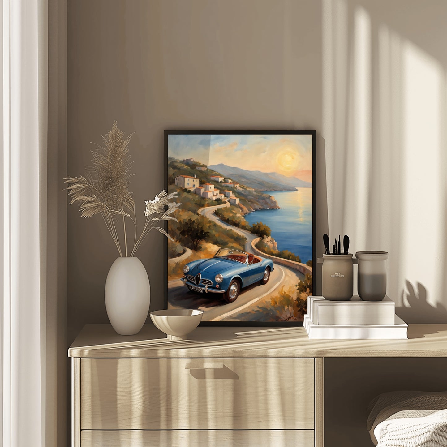Framed retro car seascape painting displayed on a wooden dresser with decorative vases and books
