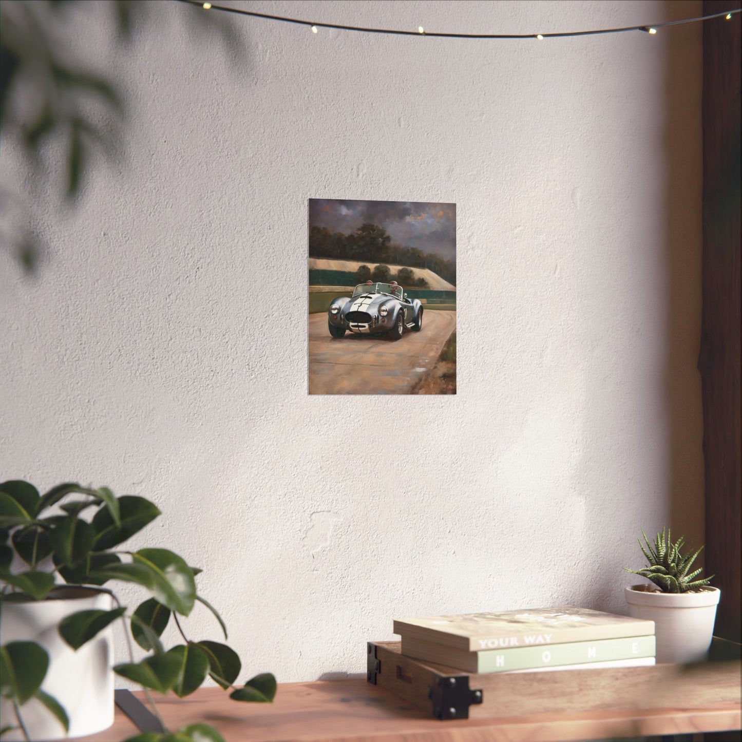 Vintage Car Art Print displayed on a wall with a potted plant and books on a wooden table