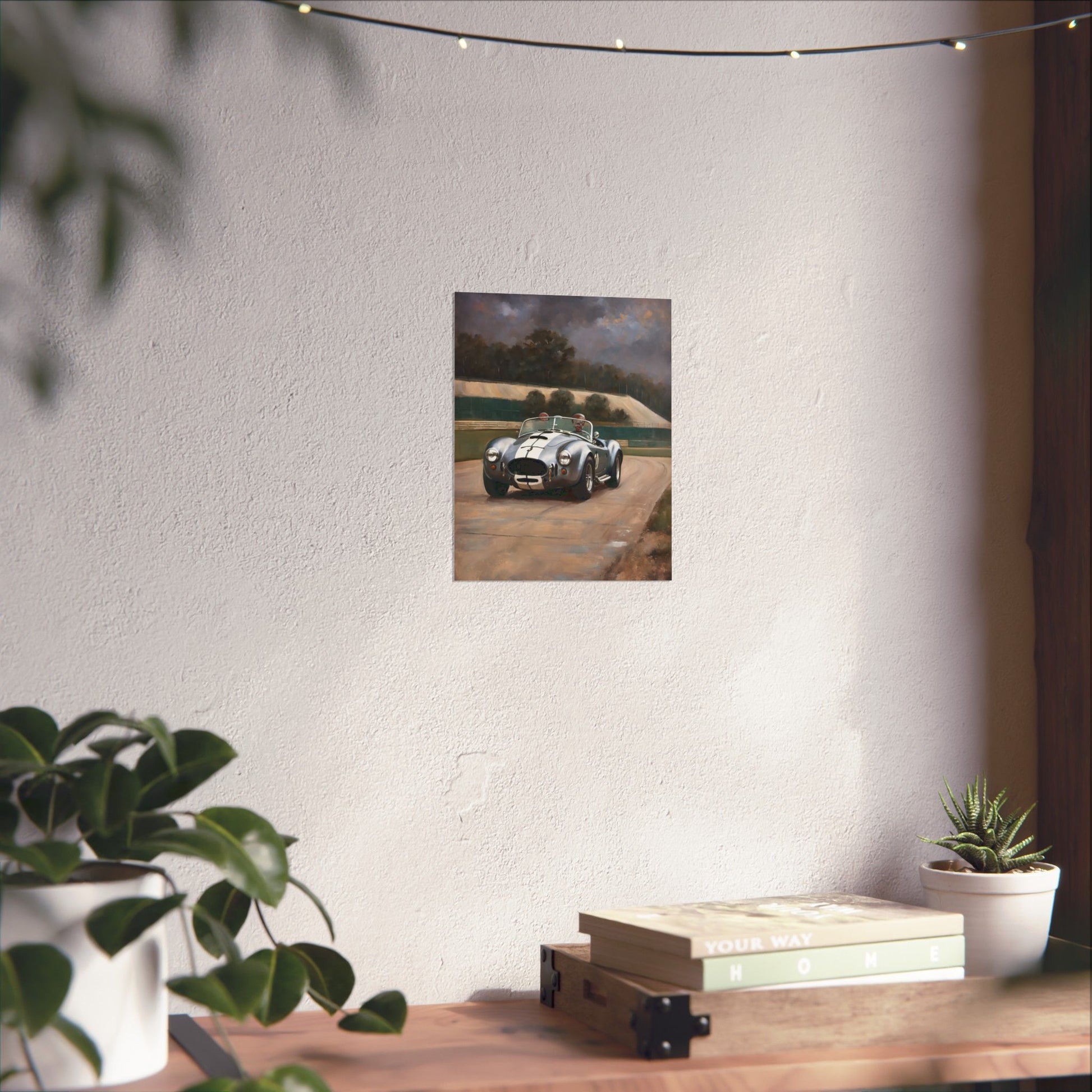 Vintage Car Art Print displayed on a wall with a potted plant and books on a wooden table